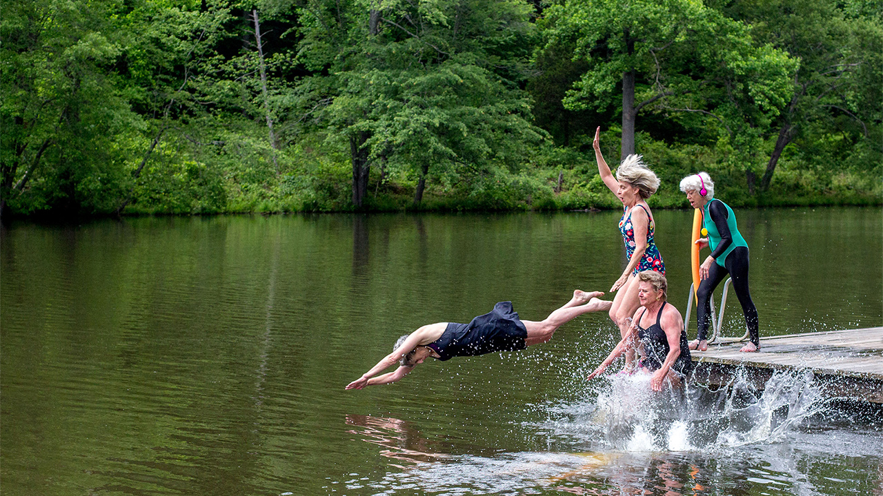 Older alumnas leaping into lake